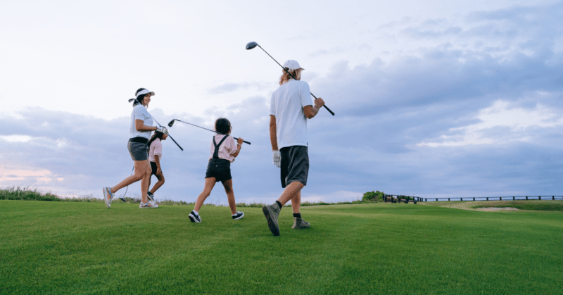 A family walking on a golf course.