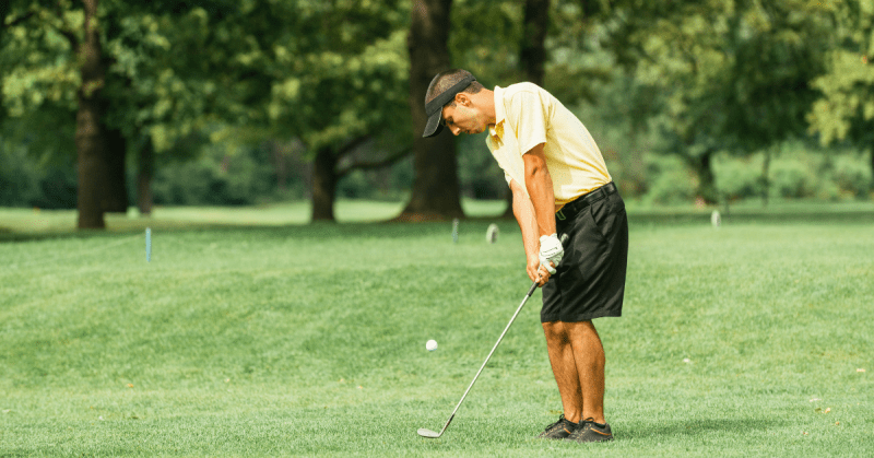 A man hitting a chip shot in golf